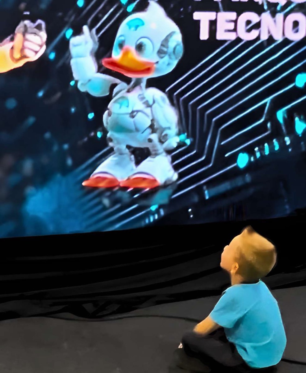 Criança observa o mascote robótico da INVENTUM em uma tela